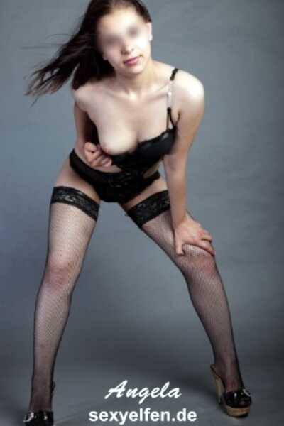 Escort Girl Angela steht in Unterwäsche bekleidet und in fordernder Pose