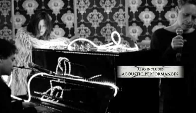 Martin Gore mit Mikrofon, links ein Mann am Piano, im Hintergrund Johana Wokalek